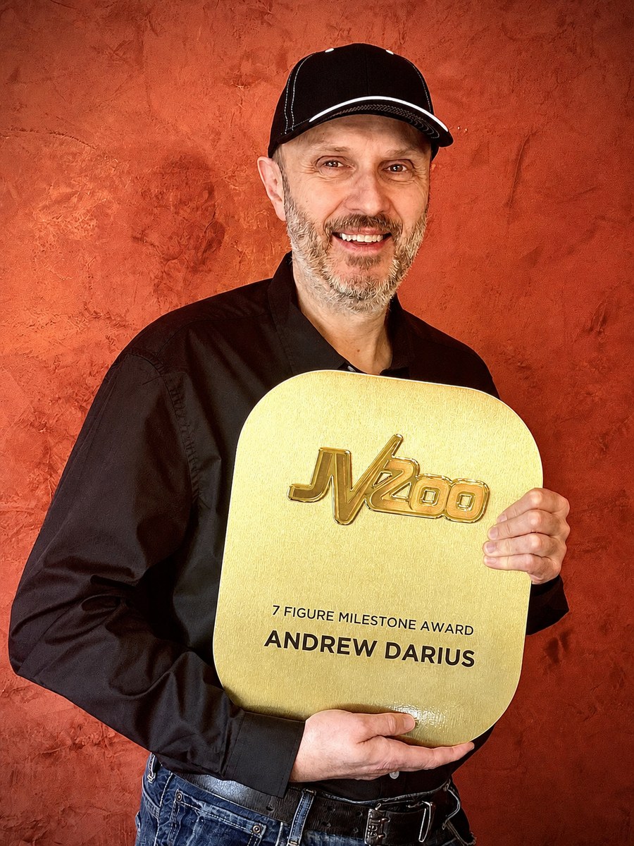 Andrew Darius holding the JVZoo 7-Figure Milestone Award plaque.